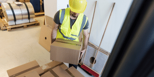 Man lifting up a box safely.