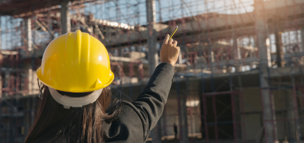 Girl pointing at a building site.